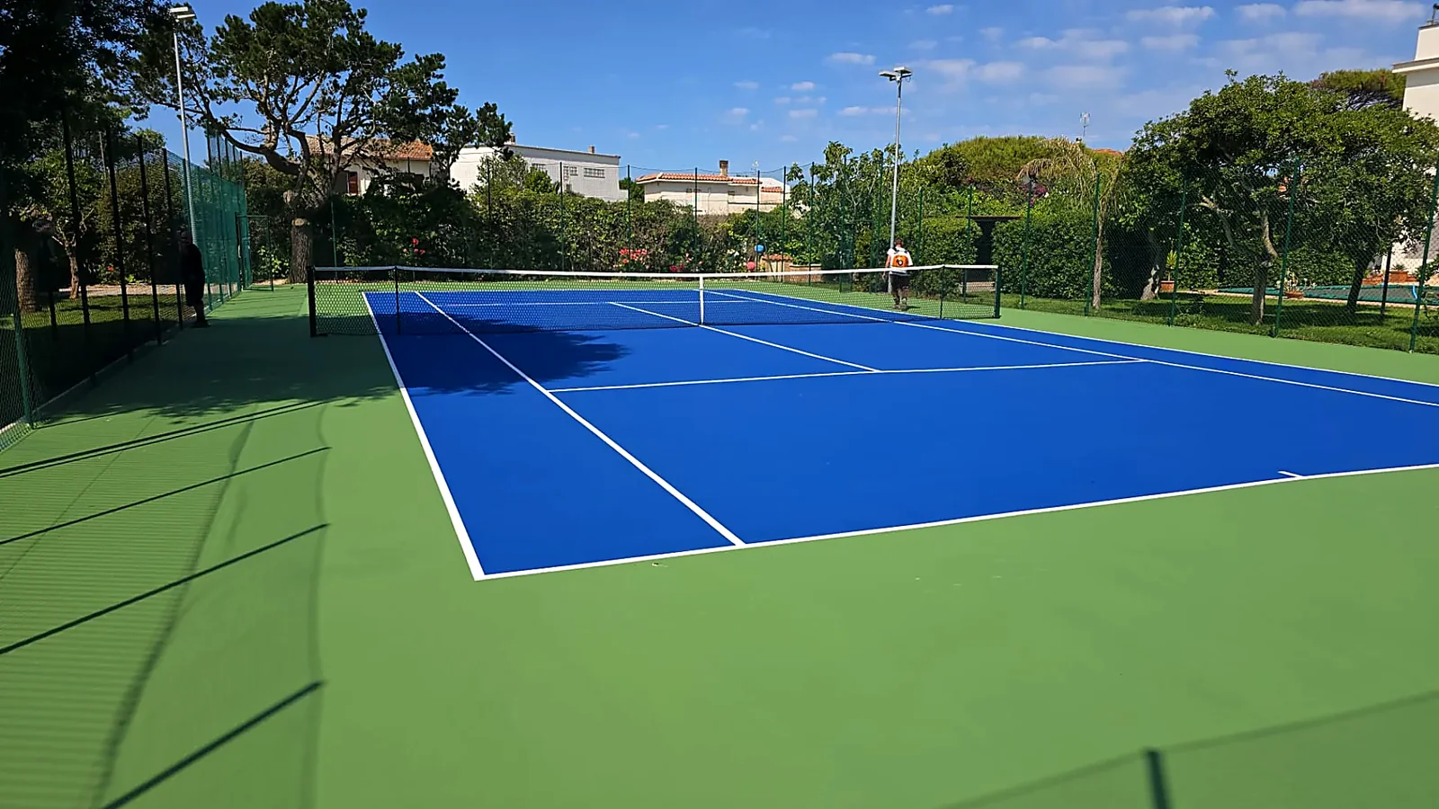 Campo da tennis blu e verde immerso nel verde