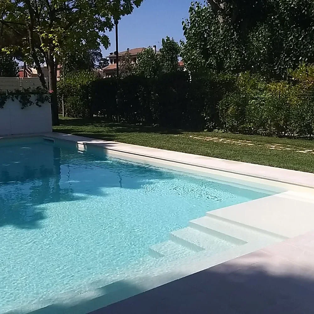 Piscina con acqua cristallina e bordo chiaro